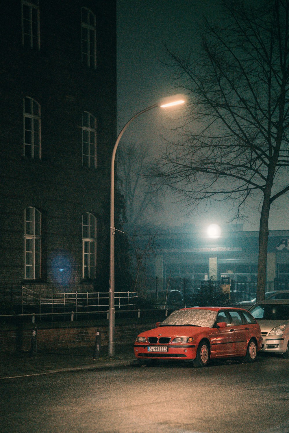 two cars parked on the side of the road at night