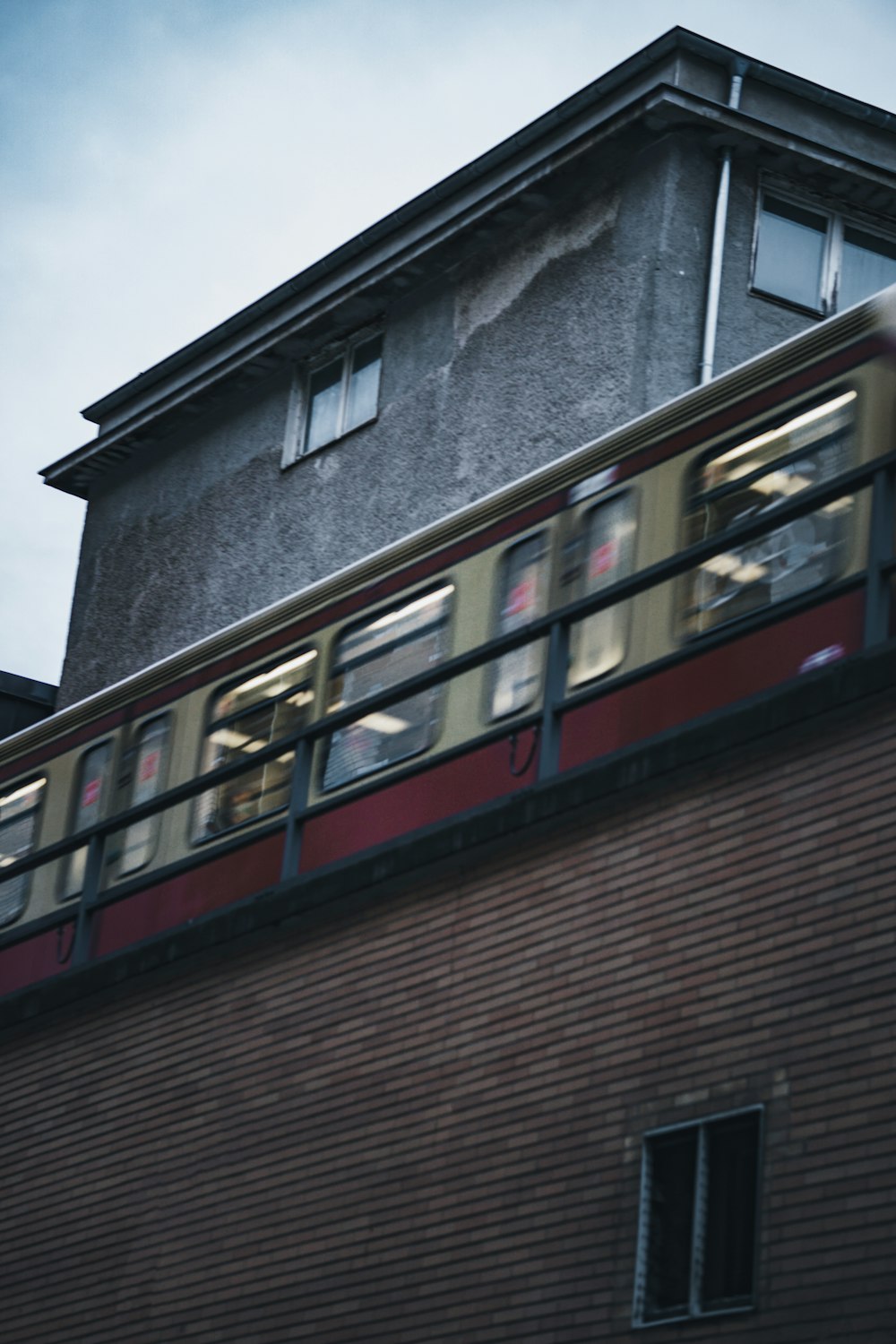 a train traveling past a tall brick building