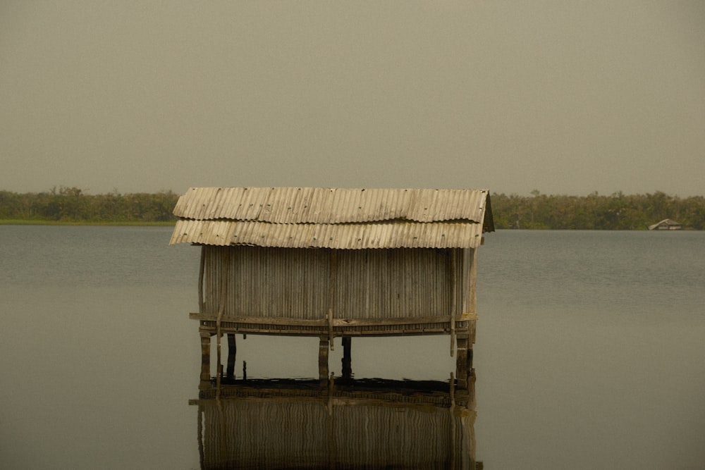 a small hut sitting in the middle of a lake