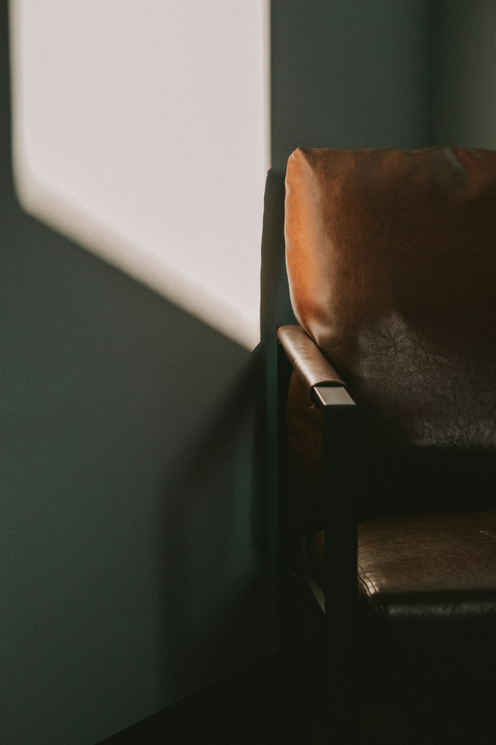 a brown chair sitting in a corner of a room