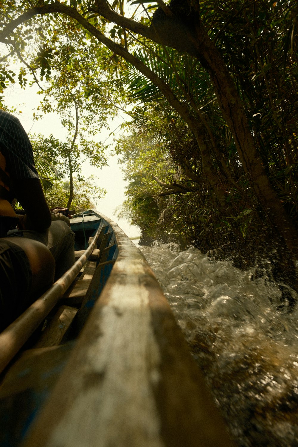 a man riding on the back of a boat down a river