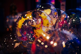 A collection of transparent balloons filled with lights and illustrations of a popular animated character. Many balloons overlap, creating a vibrant and festive atmosphere with reflections and bokeh effects in the background.