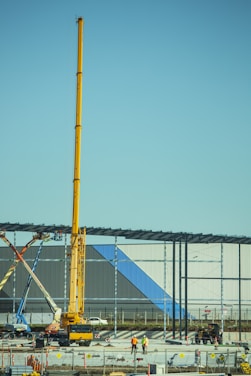 Construction workers collaborating on a building site with cranes in the background