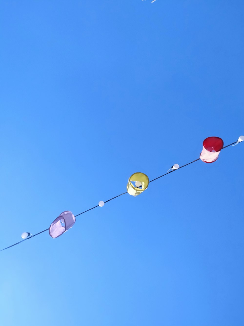 a long string of colorful kites flying in the sky