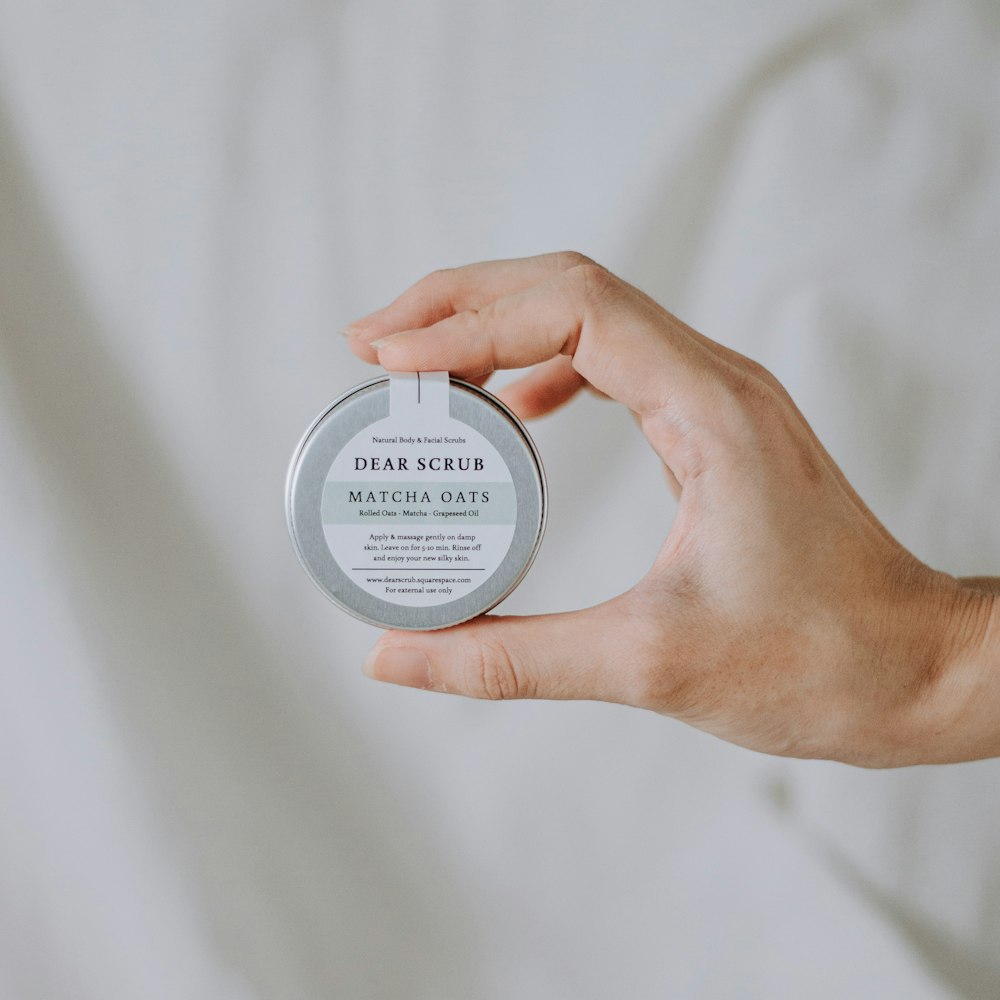 a person holding a tin of soap in their hand