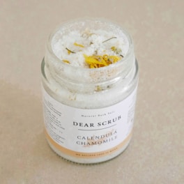 Close-up of natural body scrub ingredients like sea salt and lavender petals.
