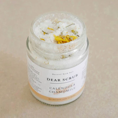Colorful organic bath salts in eco-friendly packaging with natural flowers around