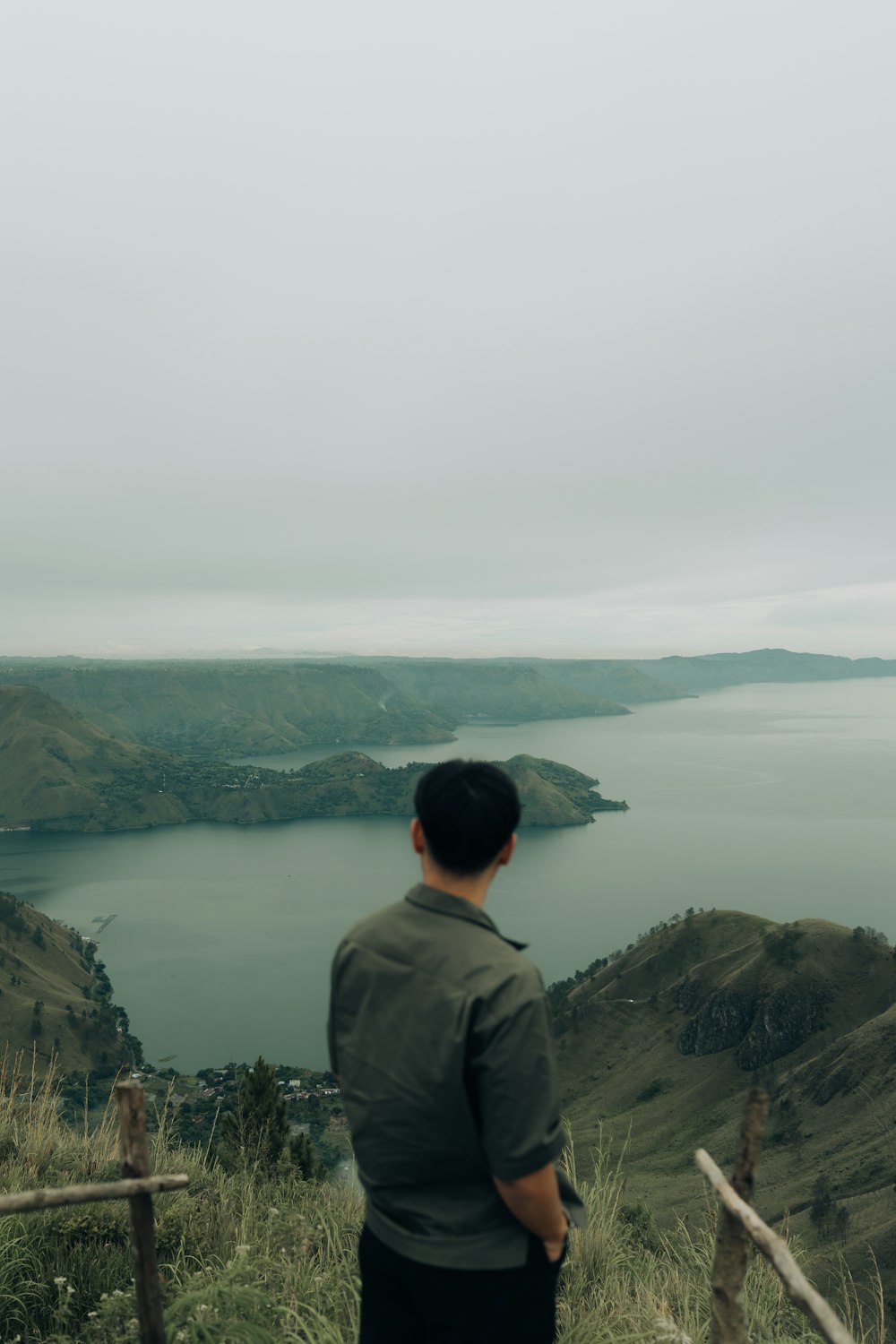 a man standing on top of a lush green hillside