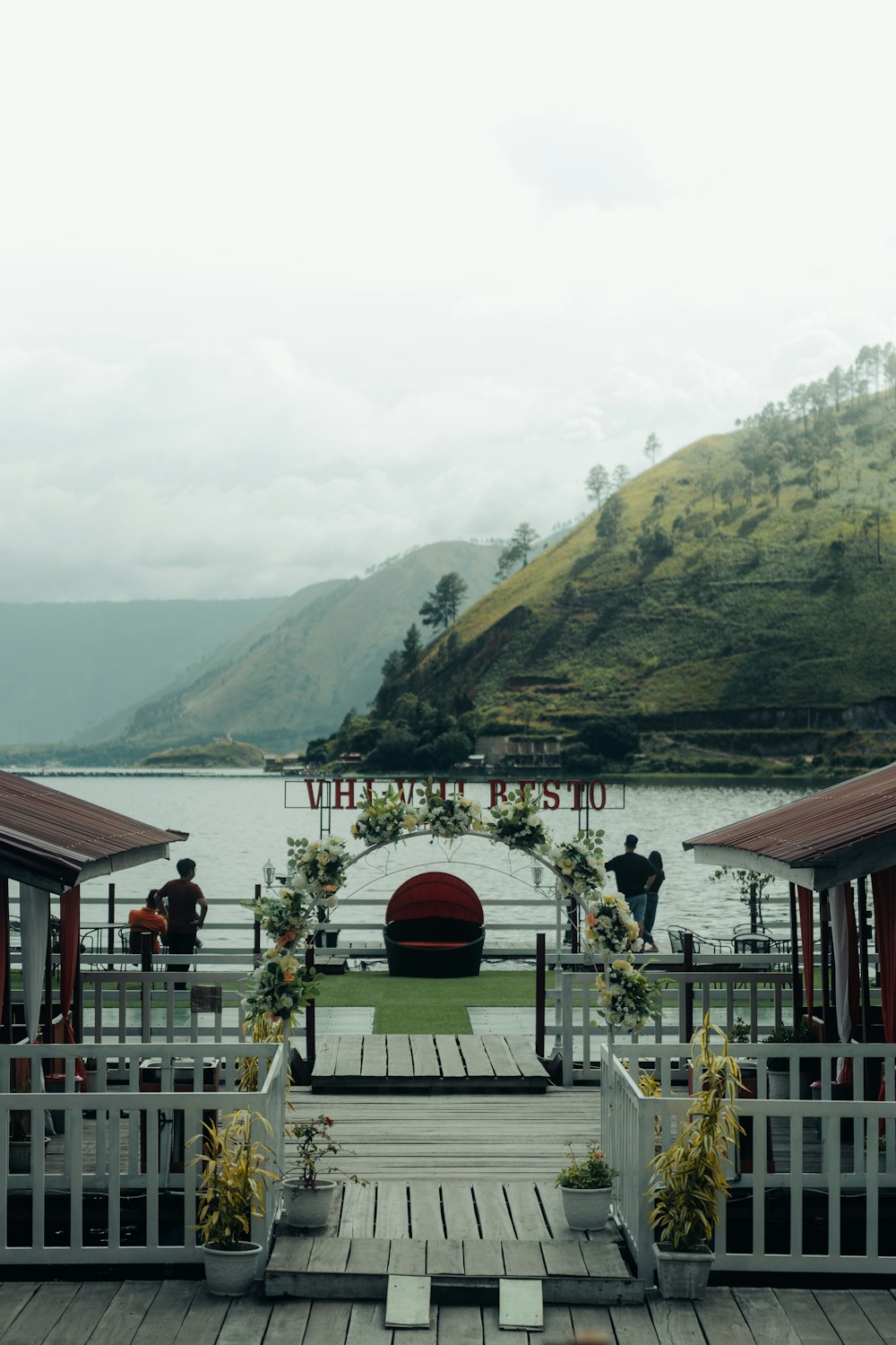 a wooden dock with a white fence and a sign that says welcome