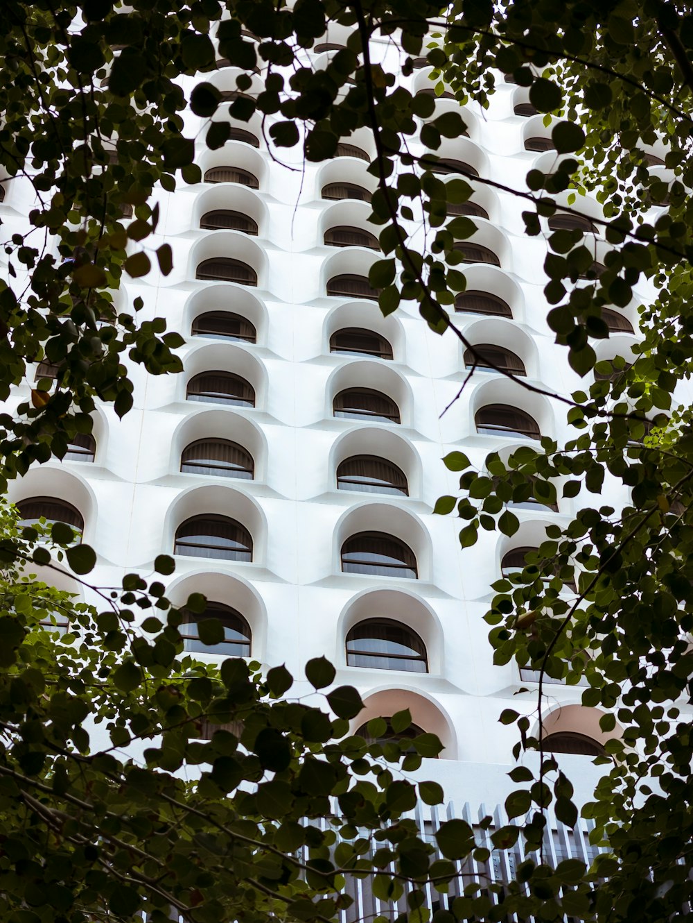 a tall white building with many windows and a clock on it's side