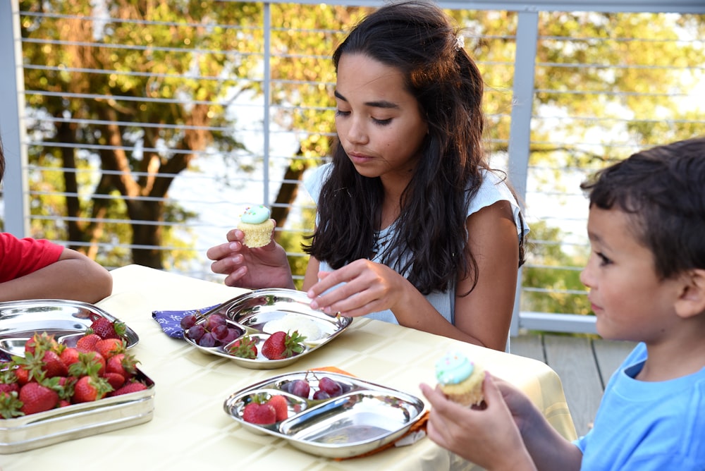 a group of children sitting around a table eating food