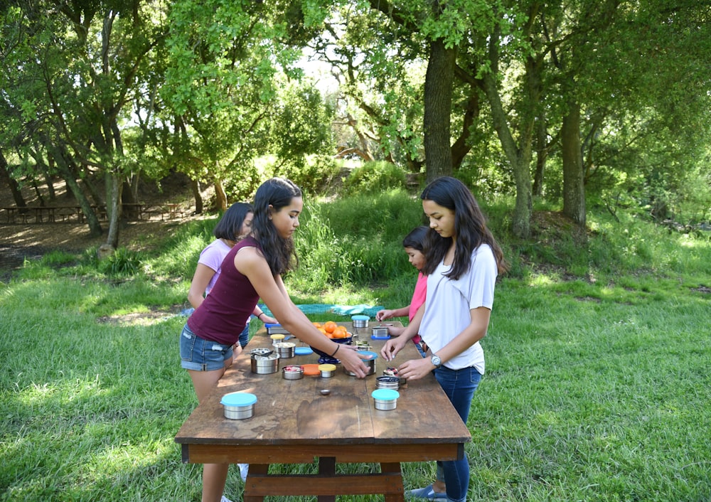 Un grupo de chicas de pie alrededor de una mesa de picnic