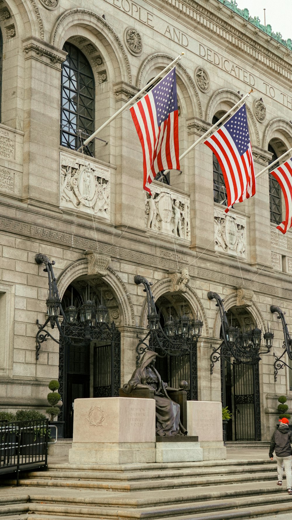 a statue of a man holding a flag in front of a building