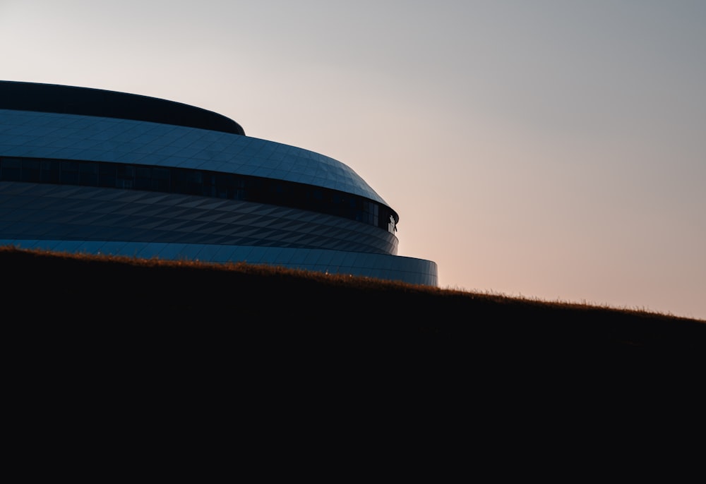 a building on a hill with a sky in the background