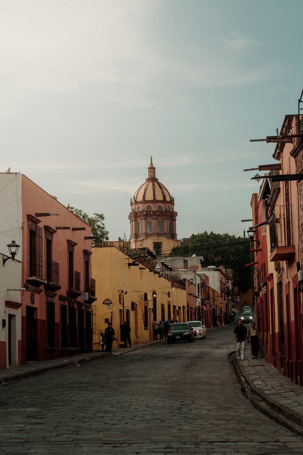 a cobblestone street with a church in the background