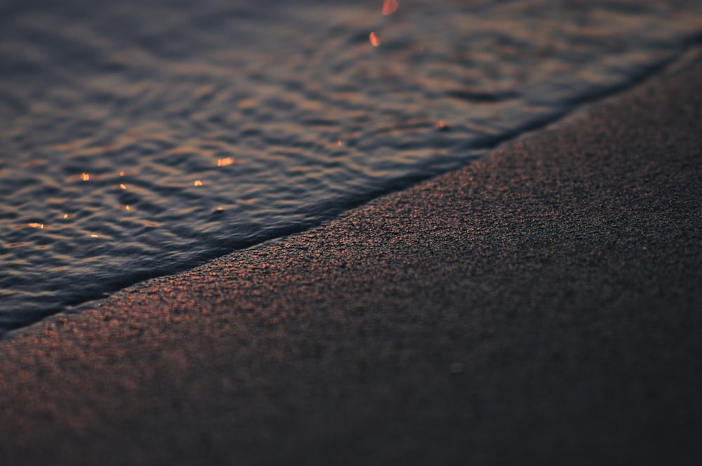 a close up of the sand and water of a beach