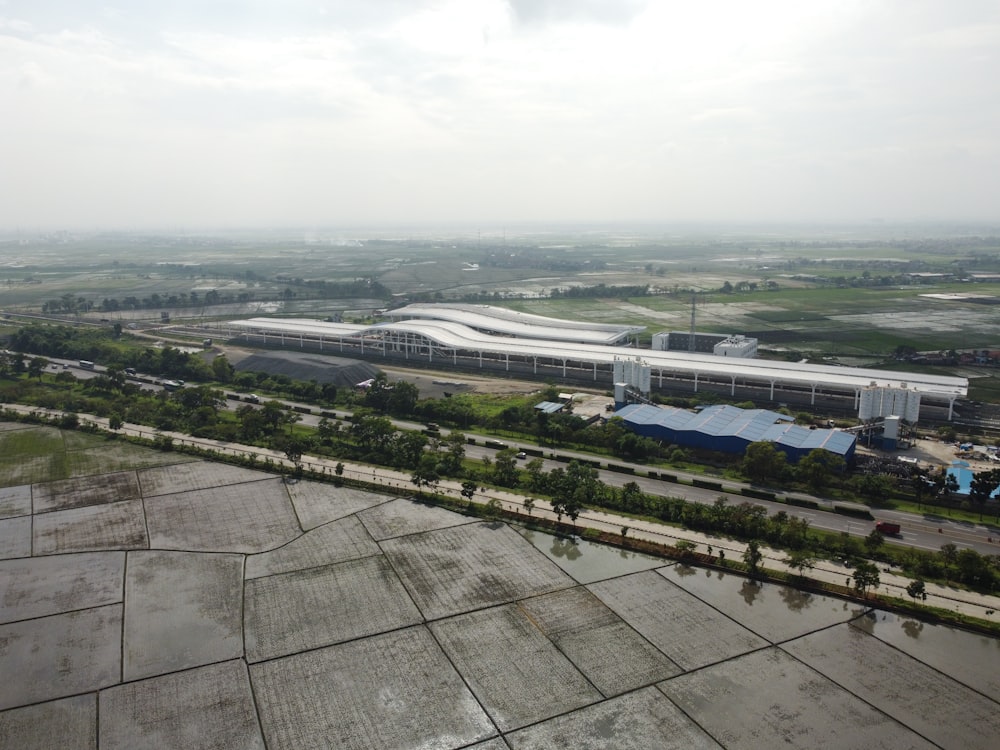 an aerial view of an airport with a large building in the background