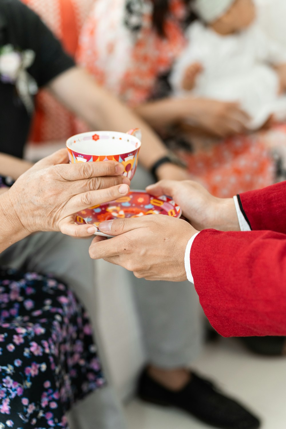 a man and a woman holding a cup in their hands