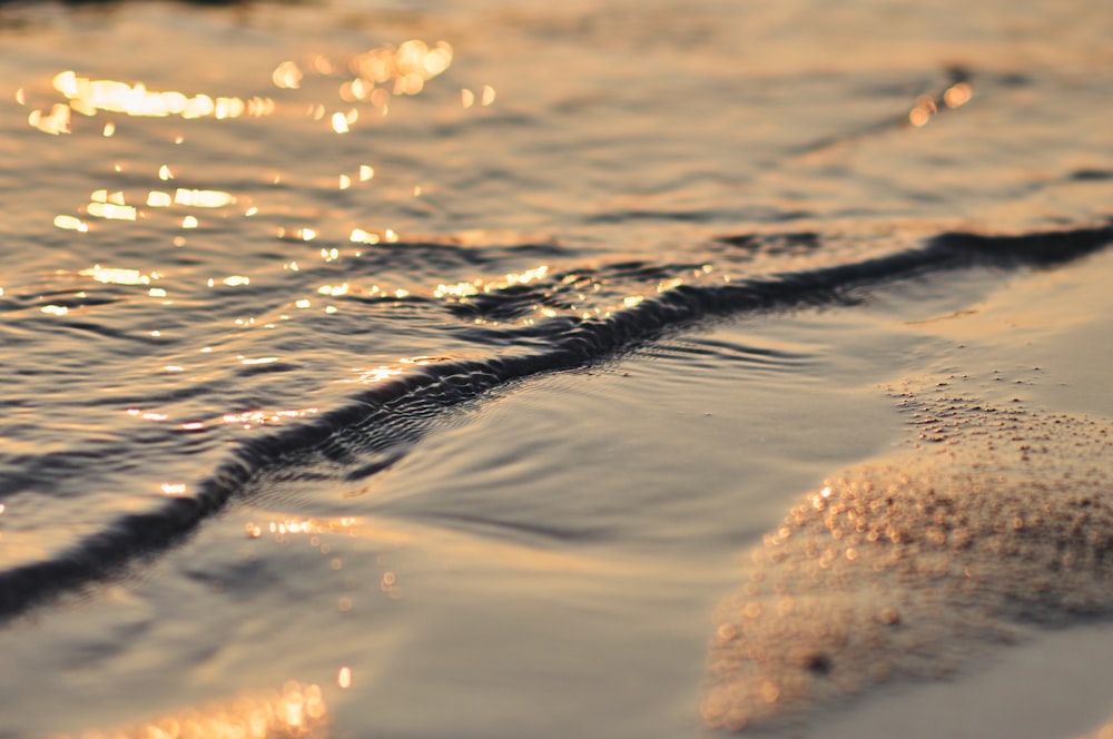 a close up of water and sand on a beach