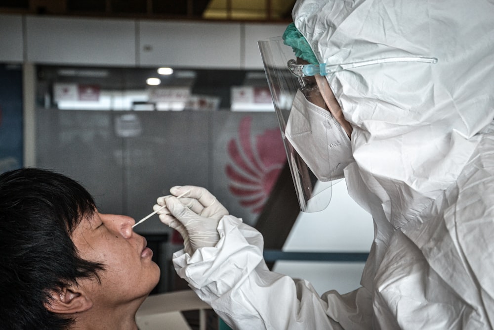 a man in a white suit is putting something in his mouth