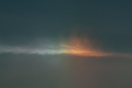 A serene sunrise breaking through dark clouds over a quiet hospital room window.