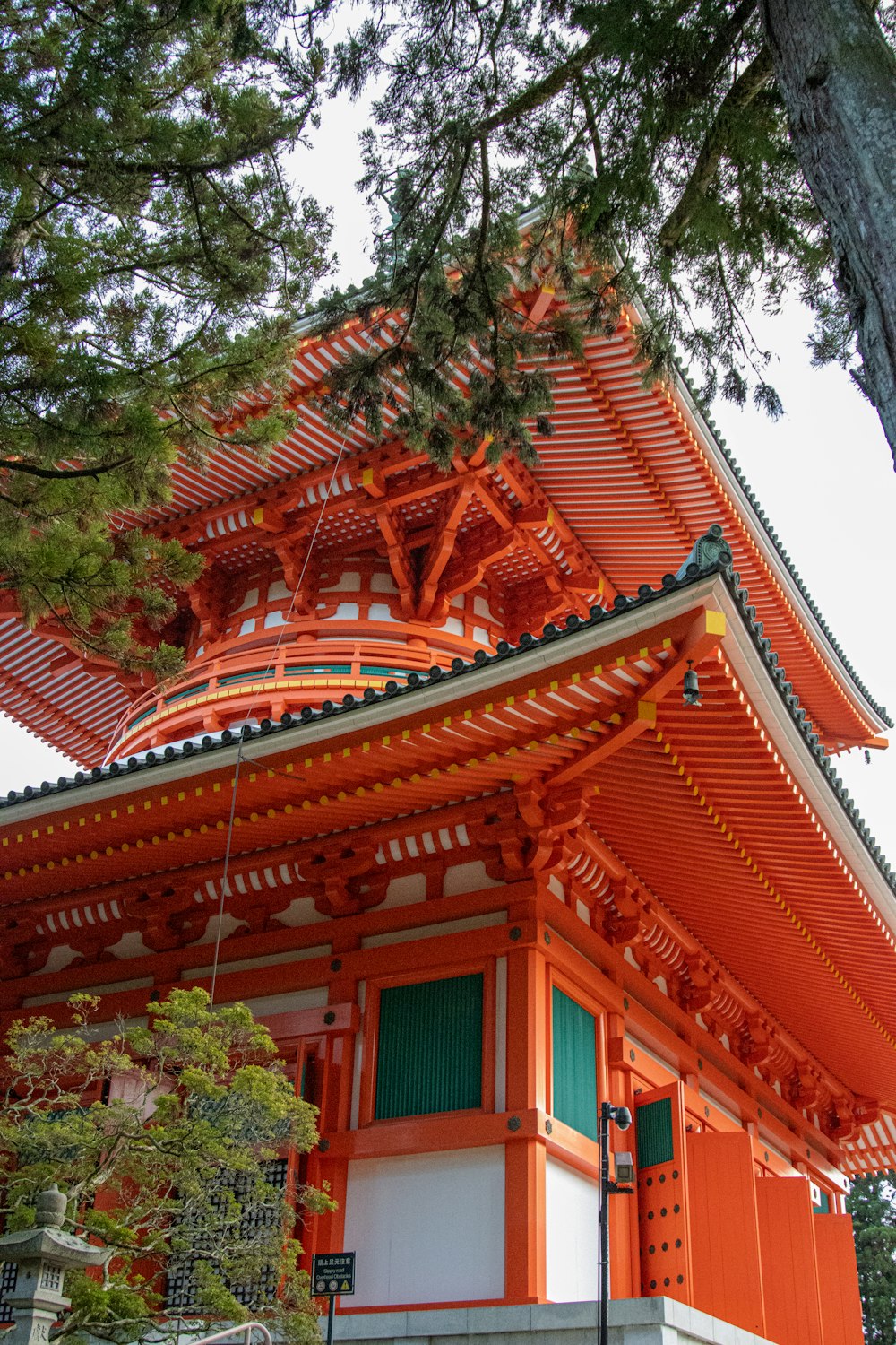 a tall orange building sitting next to a tree