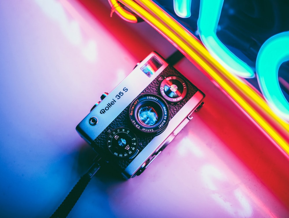 a camera sitting on top of a table next to neon lights