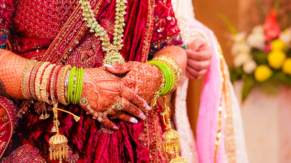 a close up of a bride's hands and bracelets
