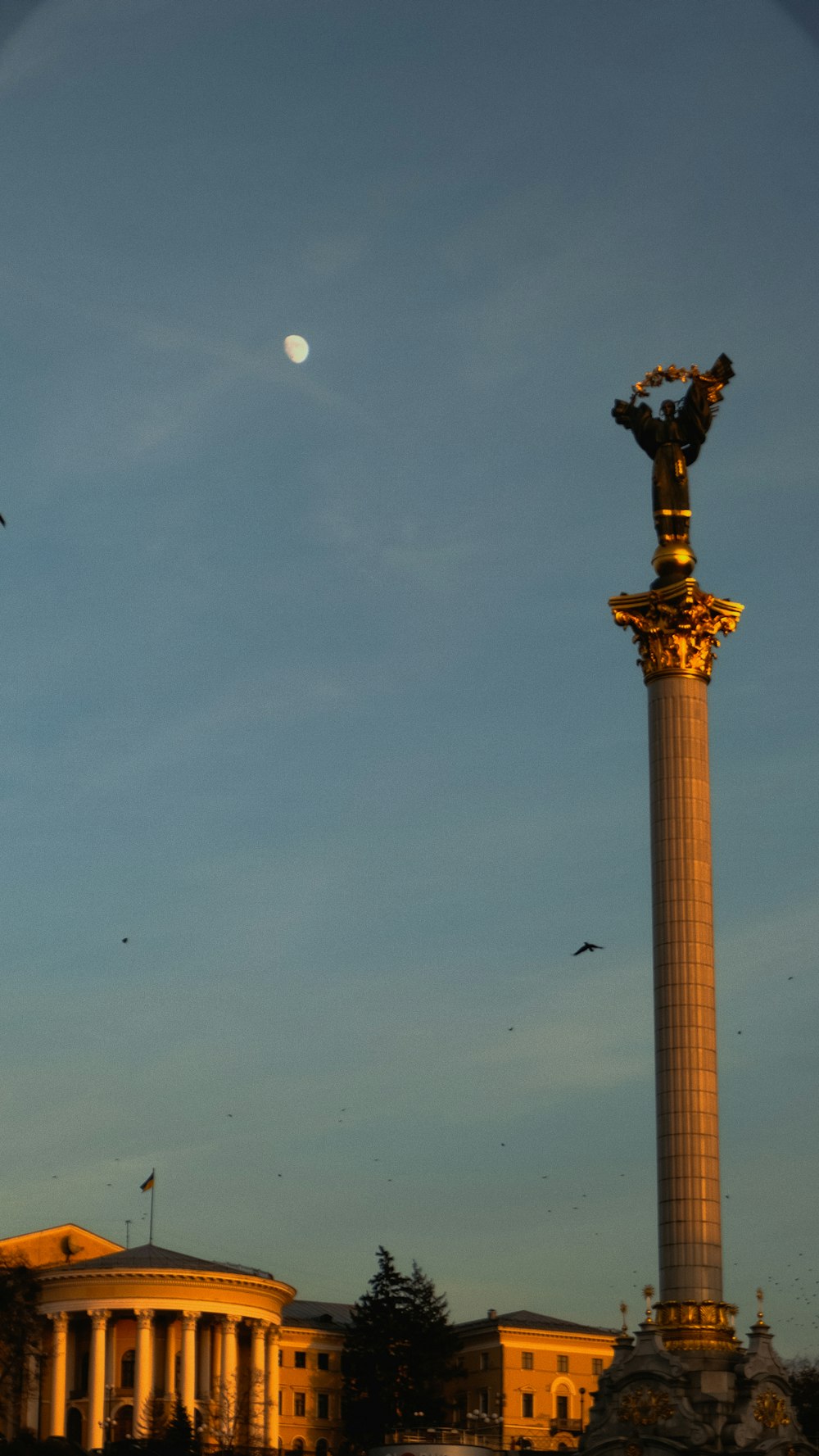 a tall monument with a bird flying in the sky