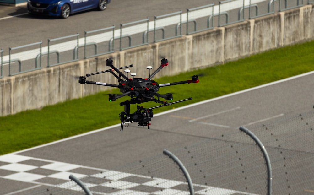 a small helicopter flying over a race track