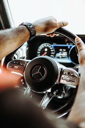 a man driving a car with a steering wheel