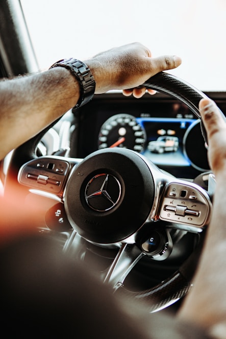 a man driving a car with a steering wheel