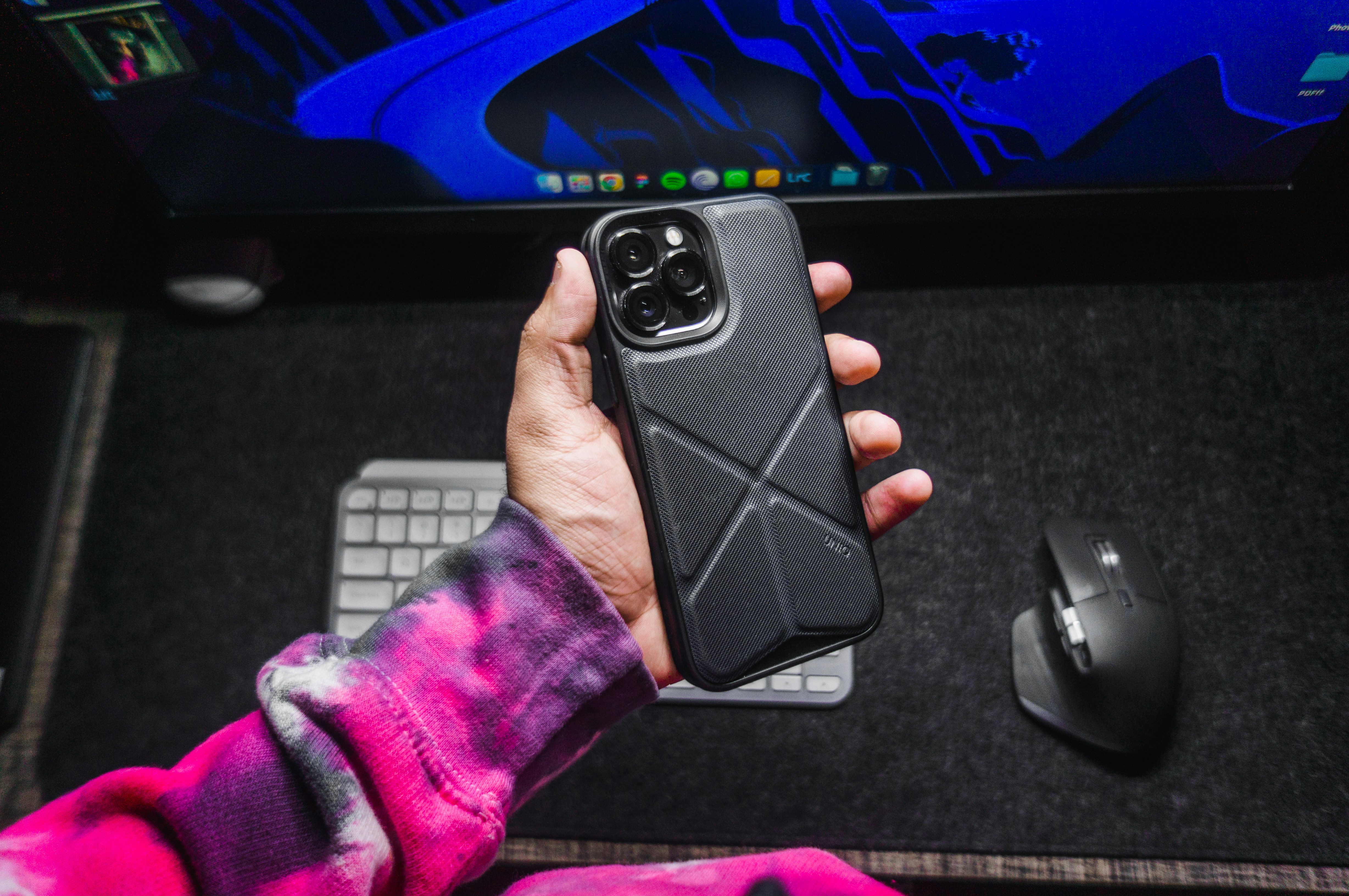 a person holding a phone in front of a computer