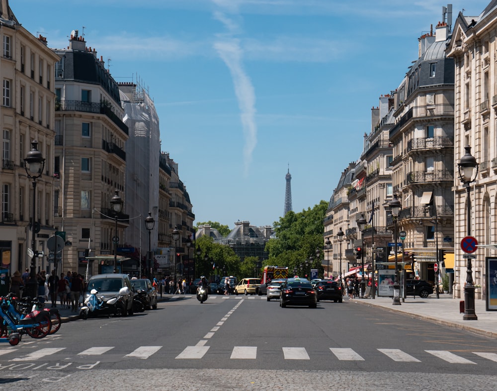 a view of a street with cars, motorcycles, and a eiffel tower