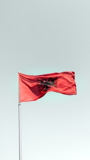 a red flag flying in the wind on a clear day