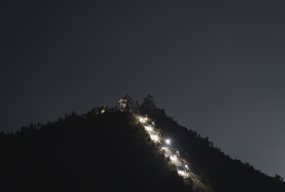 a long line of lights on a hill at night