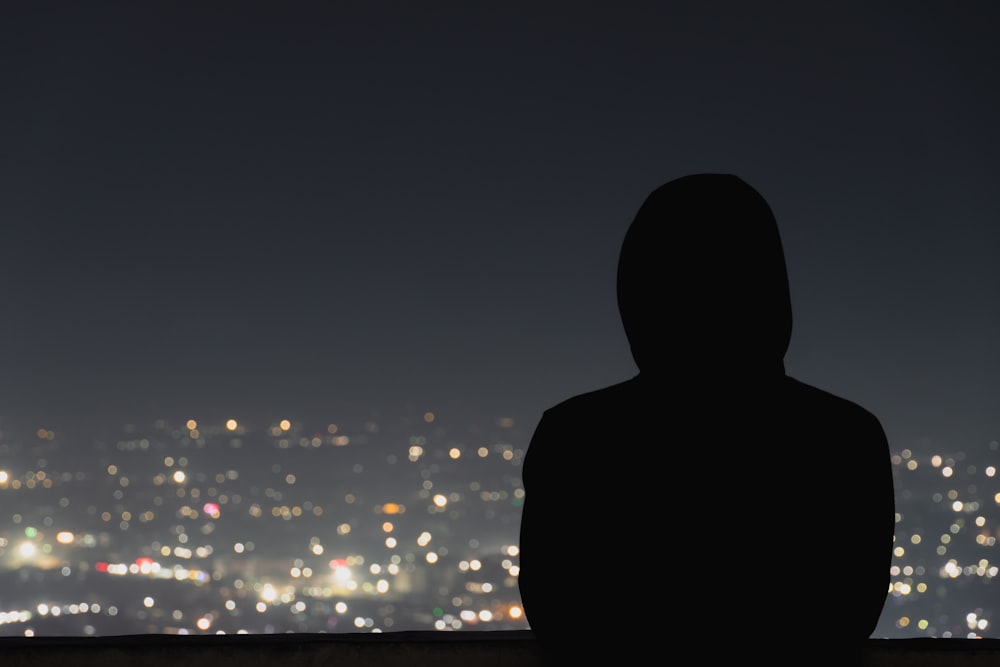 a person standing in front of a city at night