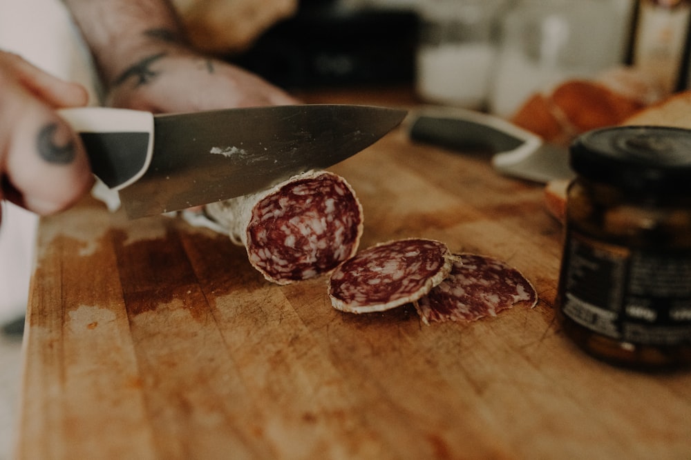 a person cutting up some food on a cutting board