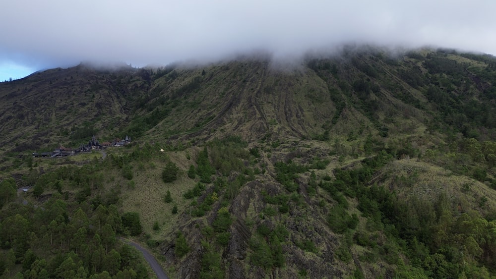 a very tall mountain covered in clouds and trees