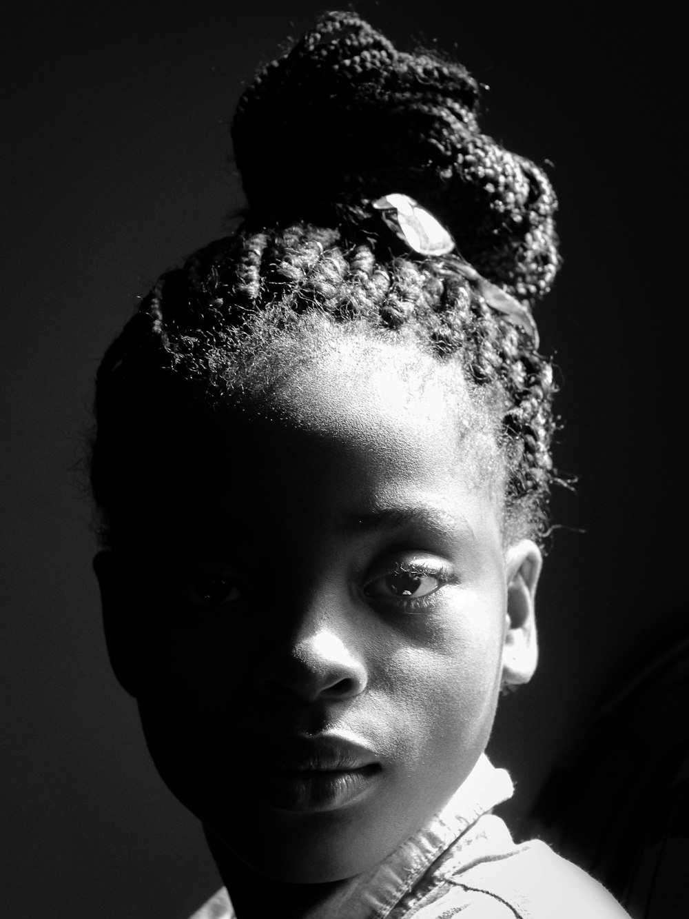 a black and white photo of a woman with a bun in her hair