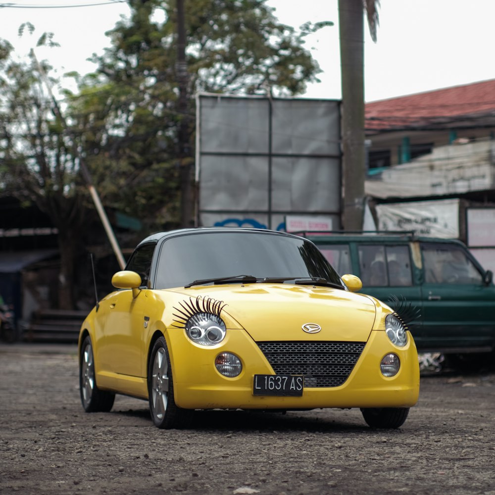 a small yellow car parked in a parking lot