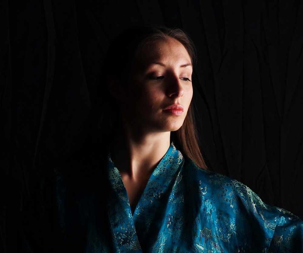 a woman with her eyes closed wearing a blue robe