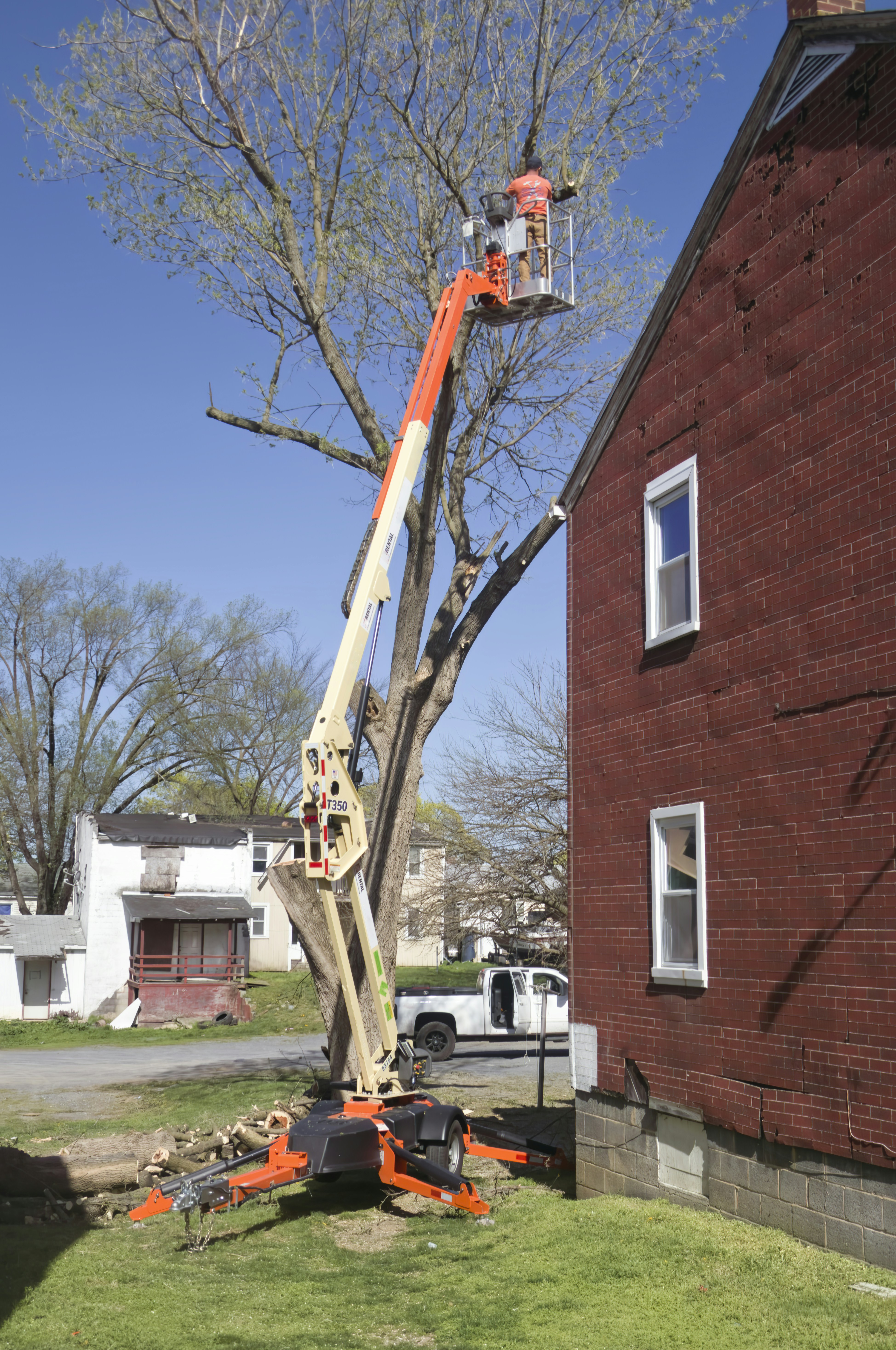 Overhanging branches being trimmed near a roof
