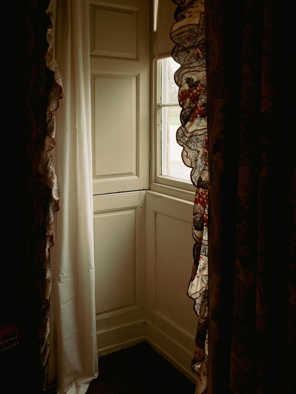 ein Zimmer mit Fenster und Vorhang