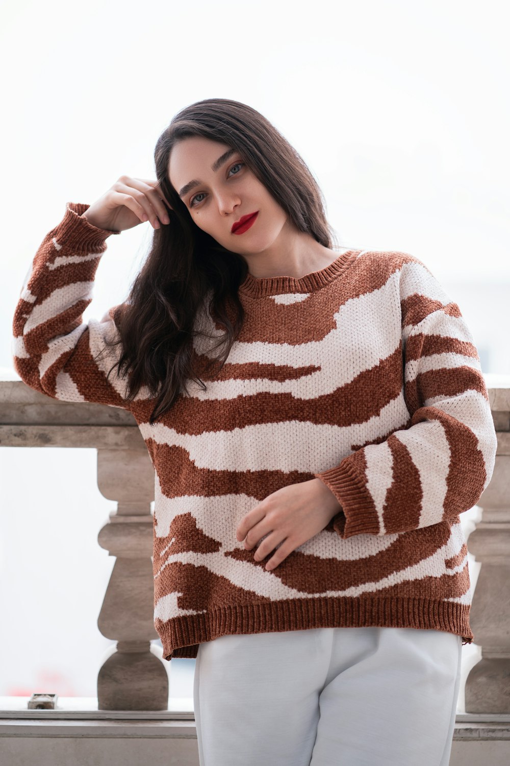 a woman wearing a brown and white sweater