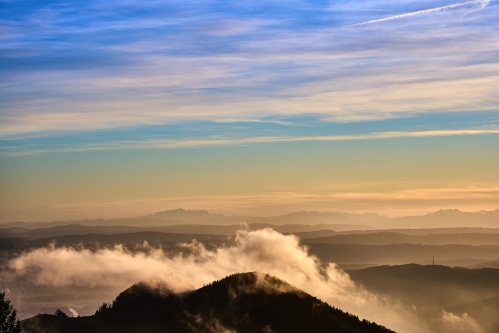 a view of a mountain covered in clouds