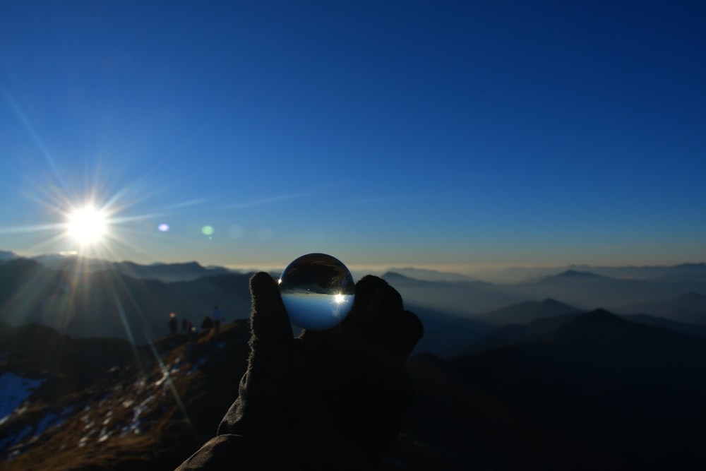 a person holding a glass ball in their hand