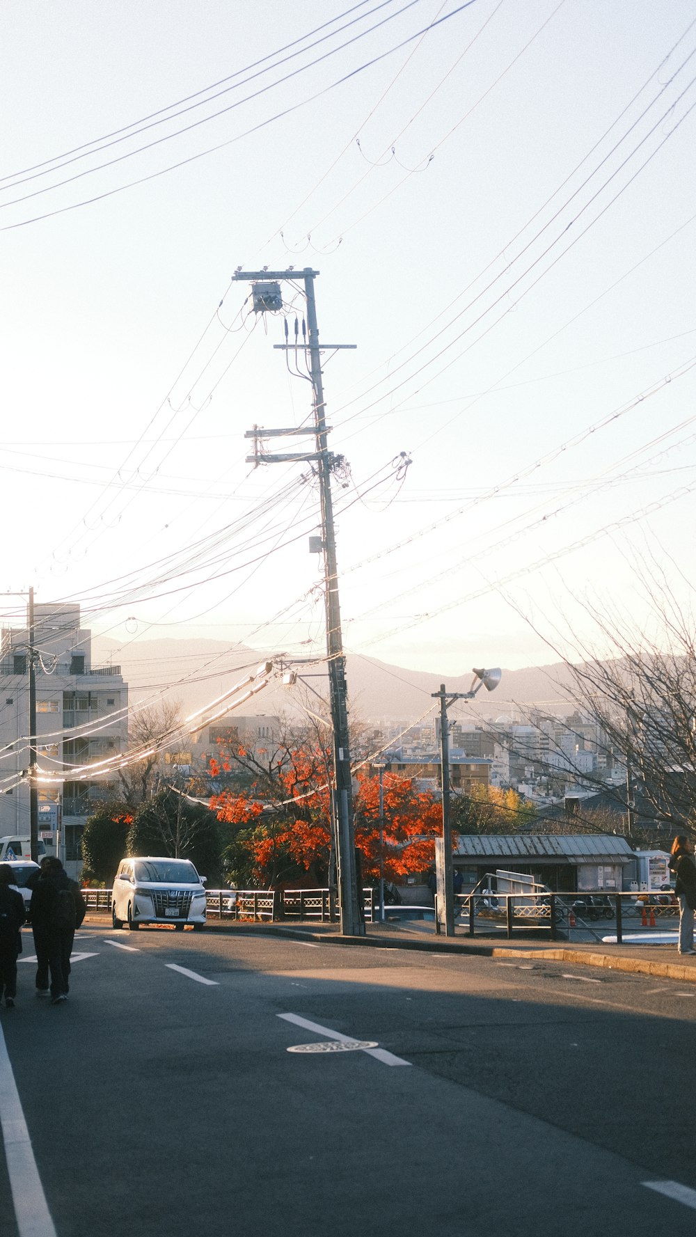 a group of people walking down a street next to power lines
