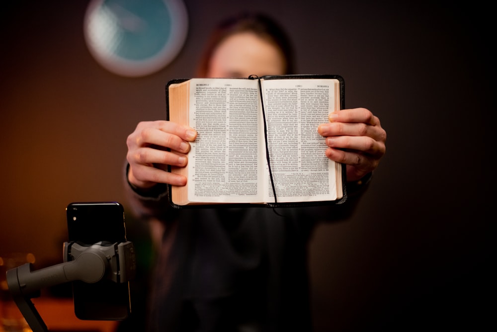 a person holding an open book in their hands