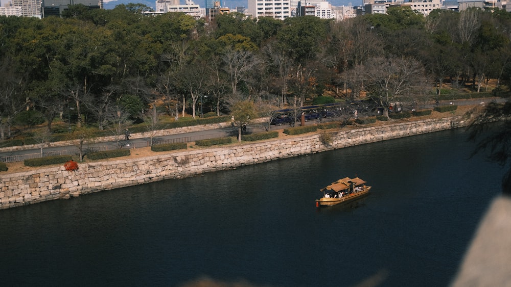 a boat traveling down a river next to a city